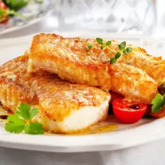 Polędwica z dorsza w piekarniku z warzywami, podana z pomidorkami i ziołami.