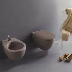 Nowoczesna łazienka z bidetem, który służy do higieny intymnej. Obok toaleta i stylowe dodatki.