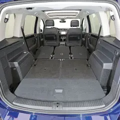 Wnętrze VW Touran z rozłożonymi siedzeniami tworzy dużą przestrzeń bagażową. Poznaj vw touran wymiary i możliwości transportowe.
