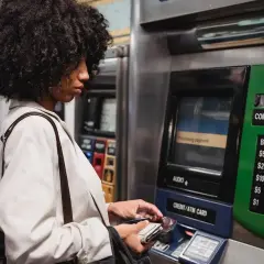 Kobieta z burzą włosów dokonuje płatności na stacji metra, korzystając z bankomatu. To jej millenium wypłata z innego bankomatu, bo ten jest bliżej.