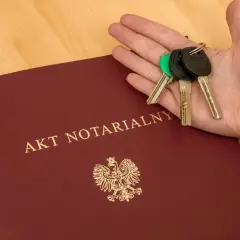 Dłoń z kluczami spoczywa na akcie notarialnym o majątku osobistym.