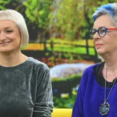Dwie kobiety, jedna z krótkimi blond włosami, druga z siwymi z niebieskimi pasemkami, rozmawiają. Może facet 30 lat bez dziewczyny szuka rady u przyjaciółki?