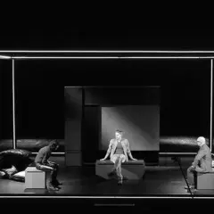 Trzech mężczyzn na scenie, w minimalistycznej scenografii. Spektakl "Ludzie inteligentni" wciąga widza w refleksję nad ludzką naturą.