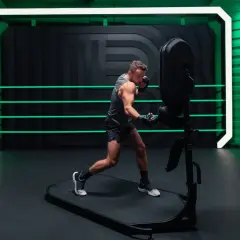A man in boxing gloves practices his jab and cross, demonstrating proper boxing terminology in a futuristic ring with neon green accents.