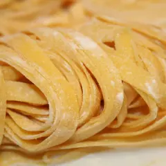 Pâtes fraîches aux œufs, enroulées en nid, saupoudrées de farine.
