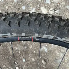 Close-up of a Schwalbe Rocket Ron tire on a mountain bike wheel, ready for a review. The tread is visible, along with rim details.