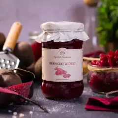Słoik buraczków wiórków, gotowych do podania na obiad. Obok świeże buraki i tarka.