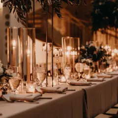 Elegancka sala weselna z długim stołem, świecami i kwiatami. Zastanawiasz się, ile kosztuje sala weselna?