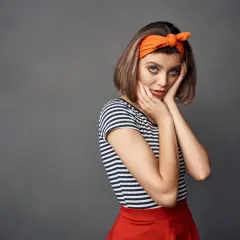 Dziewczyna z pomarańczową opaską z kokardką na głowie, inspiracja jak uszyć opaskę z kokardką.