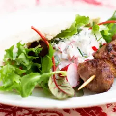 Saftiga kebabspett i ugn serveras med pitabröd, fräsch sallad och en krämig yoghurtsås med rädisor. En perfekt middag!