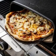 Pyszna pizza z pieczarkami i serem, właśnie wyjęta z pieca grillowego. Idealna do dzielenia się z przyjaciółmi, bo ile piec pizze, tyle radości!