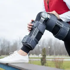 Frau mit Ganzbeinorthese, die sich auf eine Genesung vorbereitet. Informieren Sie sich über die Ganzbeinorthese Kosten.