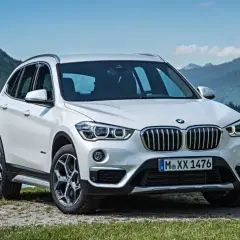 BMW X1 blanco aparcado junto a un lago. Opiniones sobre el mantenimiento de este modelo son positivas.