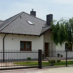 Nowy, nowoczesny dom z czarnym, metalowym ogrodzeniem. Czy to ogrodzenie bez pozwolenia?