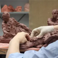 Hands sculpt clay figures, a glimpse into the dedication needed for the best sculpture schools.