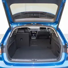 Błękitny Arteon Shooting Brake z otwartym bagażnikiem. Wnętrze jest przestronne, z czarną wykładziną i widocznymi tylnymi siedzeniami.