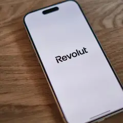 Telefon z logo Revolut na ekranie. Planujesz podróż i szukasz revolut bankomaty bez prowizji?
