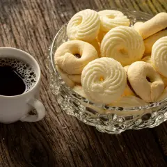 Kawa i miseczka pełna pysznych, delikatnych ciastek. Idealne na chwilę relaksu.