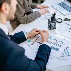 Ludzie analizują wykresy i raporty, planując strategię. To pokazuje, gdzie można pracować po zarządzaniu.