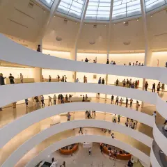 Wnętrze muzeum z krętymi rampami i zwiedzającymi.