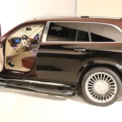 Mercedes-Maybach GLS z otwartymi drzwiami, widoczne luksusowe wnętrze i dwukolorowe nadwozie.