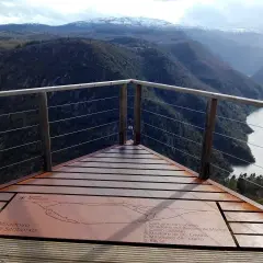Mirador de Santiorxo con vistas a un río serpenteante entre montañas boscosas y picos nevados.