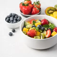 Kolorowa sałatka owocowa z truskawkami, kiwi, mango i borówkami. Idealna na zdrową przekąskę, zawiera owoce o niskim indeksie glikemicznym.