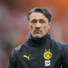 Kovac trener w czarnej kurtce z logo BVB, skupiony na boisku.