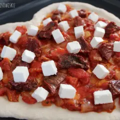 Serce z ciasta z sosem pomidorowym, suszonymi pomidorami i kostkami sera feta.