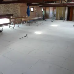 Pannelli per insonorizzare il pavimento in fase di posa, con tubi e attrezzature da cantiere.