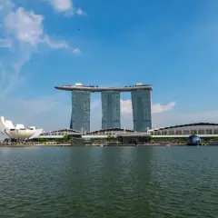 Widok na Marina Bay Sands, gdzie jest Singapur. Woda, nowoczesne budynki i niebieskie niebo.