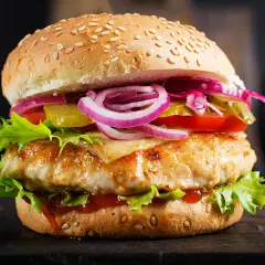 Apetyczny burger drwala podwójny z soczystym kurczakiem, serem, chrupiącą sałatą, pomidorem, ogórkiem i czerwoną cebulą.