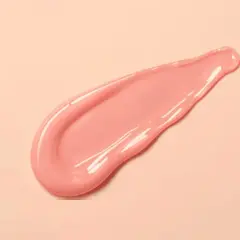 En rosa, glansig sträng av pdrn serum på en ljusrosa bakgrund.