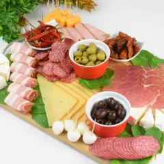 Patera wędlin i serów: salami, szynka, prosciutto, sery, oliwki, suszone pomidory i papryczki chili.