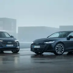 Dwa Audi, SUV i sedan, błyszczą na mokrym asfalcie. Jeden z nich to potężne 3.0 TDI, gotowe na każdą drogę.