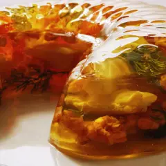 Wykwintny filet z karpia w galarecie, z dodatkiem ziół i warzyw, prezentuje się apetycznie.