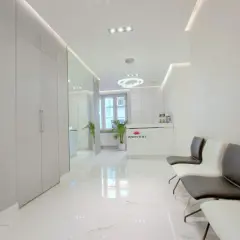 Nowoczesne wnętrze poczekalni kliniki dermatologii estetycznej z recepcją i wygodnymi fotelami.