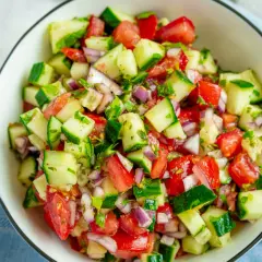 Frischer Gurken-Tomaten-Salat mit roten Zwiebeln und Kräutern – eine Idee für moderne Salate Rezepte.