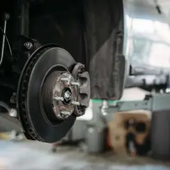 Nahaufnahme der Bremsscheibe und des Bremssattels eines PKW, bereit für Wartung oder Reparatur.