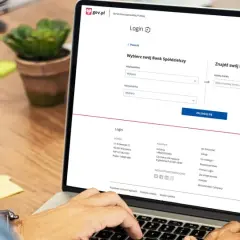 Na ekranie laptopa widzimy stronę logowania do Profilu Zaufanego. Użytkownik szuka swojego Banku Spółdzielczego, aby założyć profil zaufany w Santander.