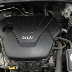 Silnik Kia Sportage GDi, widoczny pod maską, z elementami układu chłodzenia i akumulatorem.