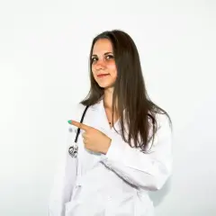 Lekarka w białym kitlu wskazuje palcem, sugerując, że tu jest rozwiązanie, jak Beloderm na problemy skórne.
