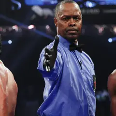 Referee signals between boxers, hinting at a close fight that could end in a majority decision vs split decision.