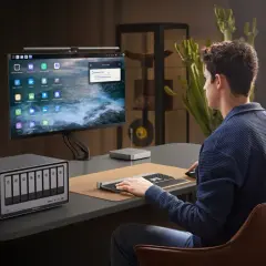 Mann arbeitet am Schreibtisch mit einer Netzwerkfestplatte SSD. Der Bildschirm zeigt eine Upload-Benachrichtigung.