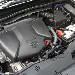 Silnik D-4D w Toyota Avensis T27. Widoczny jest czarny plastikowy dekiel silnika z logo Toyoty i napisem D-4D, akumulator oraz elementy układu dolotowego.