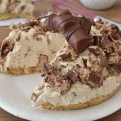 Una golosa torta kinder bueno, con crema e pezzi di cioccolato, su un piatto bianco.