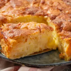 Ein Stück von einem blitzschnellen Apfelkuchen mit goldbrauner Kruste und saftiger Füllung wird mit einer Tortenschaufel herausgehoben.