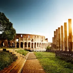 Colosseo illuminato dal sole, un'icona tra le cose da non perdere a Roma. Colonne antiche e un sentiero lastricato invitano alla scoperta.