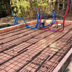 Przygotowana płyta fundamentowa z zbrojeniem i rurami instalacyjnymi, gotowa do zalania betonem.
