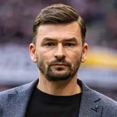 Górnik Zabrze trener, w eleganckim garniturze, patrzy prosto w obiektyw.